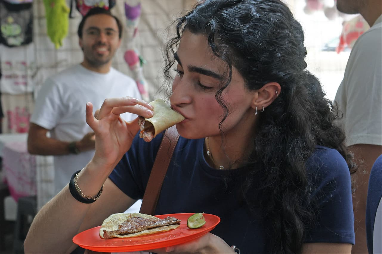 A woman eats tacos at Taqueria restaurant El Califa de Leon in Mexico City on May 15, 2024. A hole-in-the-wall taqueria is among the first restaurants in Mexico to be awarded a star by the prestigious Michelin Guide -- an accomplishment its owner credits to "love and effort". (Photo by Silvana FLORES / AFP) (Photo by SILVANA FLORES/AFP via Getty Images)