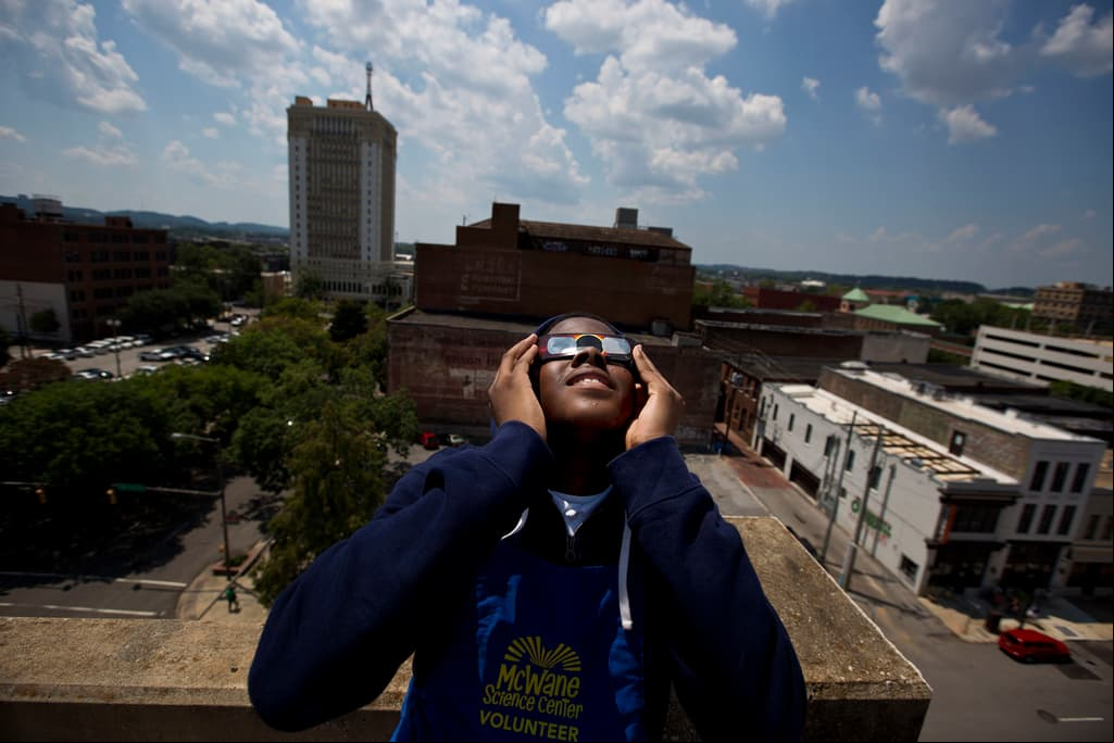 ARCHIVO - Justin Coleman, de Birmingham, Alabama, se pone las gafas en los ojos mientras observa el eclipse solar en lo alto de un aparcamiento, el lunes 21 de agosto de 2017, en Birmingham. Las gafas seguras para eclipses solares bloquean los rayos ultravioleta del sol y casi toda la luz visible. Cuando se usan en interiores, solo las luces muy brillantes deberían ser ligeramente visibles, no los muebles ni el papel pintado. (AP Photo/Brynn Anderson, Archivo)